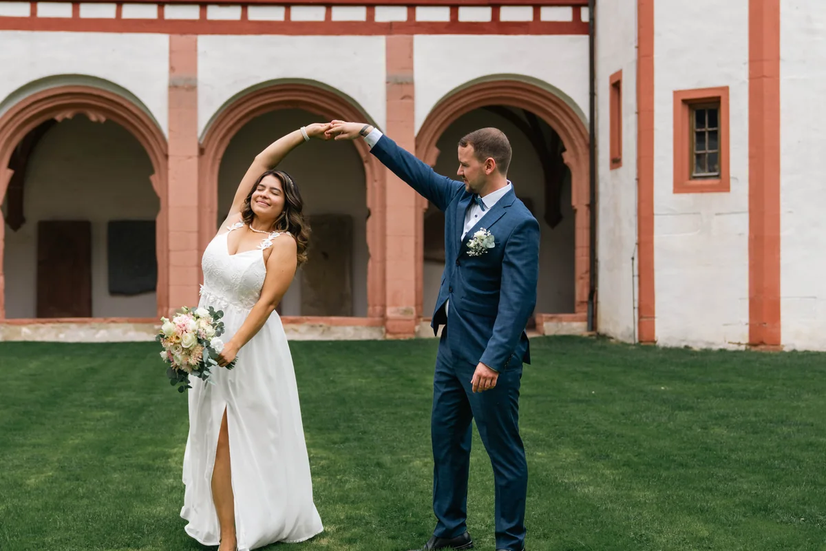 Wedding couple moving playfully through a courtyard