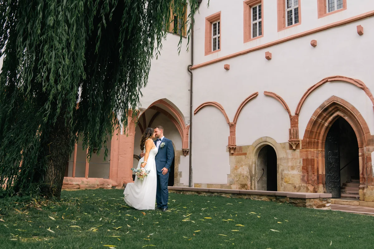 Wide wedding scene in a leafy courtyard