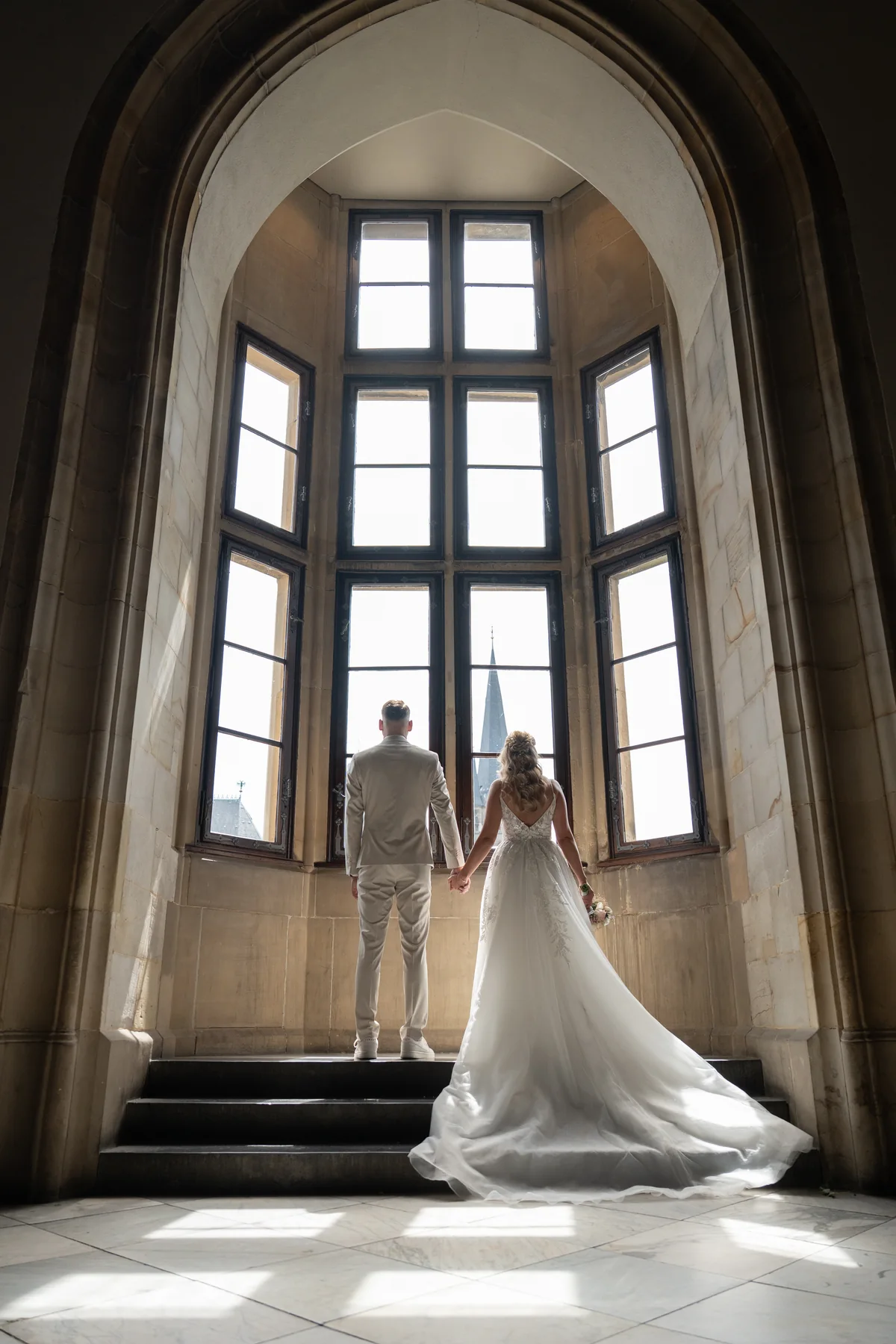 Wedding couple in the light of a tall window